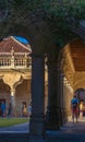 Tourists walking through the hallway of the cloister of the University of Salamanca with the columns and arches projected on the