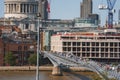 Tourists walking on Millennium bridge by City of London School building Royalty Free Stock Photo