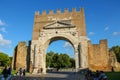 Tourists walking near the ancient arch of Augustus in Rimini, Italy Royalty Free Stock Photo