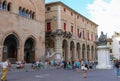 Tourists walking near Rimini City Hall and statue of Pope Paul V