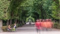 Tourists walking in park alley timelapse next to Schonbrunn Palace, imperial summer residence in Vienna, Austria. Royalty Free Stock Photo