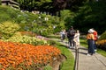 Tourists walking down to a famous sunken garden and taking pictures of the beautiful flowers.