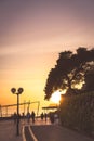 Tourists walking on a seaside promenade at dusk