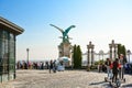 Tourists, walking and on segways, gather by the Turul bird statue overlooking Budapest, Hungary, from Buda Castle