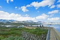 Tourists walking on a small dam at outlet of Lake Finsevatnet in Finse, Norway Royalty Free Stock Photo