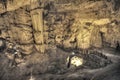 Tourists walking on stalactites cave looking infernal