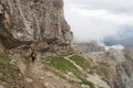 Tourists walking on a trail in mountains in a foggy day, Lagazuoi, Italian Alps Royalty Free Stock Photo