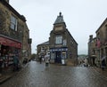 Tourists walking with umbrellas on a rainy day in the center of Howarth in West Yorkshire a historic village famous for the bronte