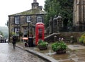 Tourists walking with umbrellas on a rainy day in the center of Howarth in West Yorkshire a historic village famous for the bronte