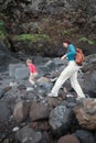 Tourists walking on volcanic rocks exploring cave Royalty Free Stock Photo