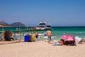 Tourists watch cruise ship arrival at Playa de Muro beach in Alcudia bay