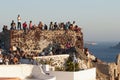 Tourists watch the sunset over the sea