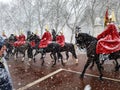 Tourists watching guard change London royal soldiers riding horses buckingham palace hyde park winter snowing snowflakes