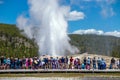 Tourists watching the Old Faithful erupting in Yellowstone National Park
