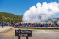 Tourists watching the Old Faithful erupting in Yellowstone National Park Royalty Free Stock Photo