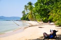 Tourists woman read books on Bamboo deck chairs on the sandy beach with bright sun and waves, Island . Relaxing day at the beach Royalty Free Stock Photo