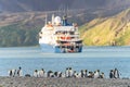 Tourists in zodiacs of an Antarctic expedition ship disembarking in Fortuna Bay on South Georgia, king penguins in the foreground.
