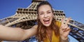 Woman taking selfie and showing victory against Eiffel tower Royalty Free Stock Photo