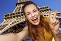 Woman taking selfie and showing victory against Eiffel tower Royalty Free Stock Photo