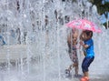 Tow asian kids play by water fountain