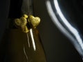 Tow golden hearts symbol of love on a neck of champagne bottle, abstract Saint Valentine background Royalty Free Stock Photo