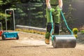 Tow Lawn Roller Pushed by Gardener