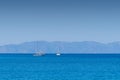 Tow sailing boats in ocean,in the background mountains