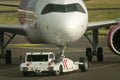 Tow tractor pushes the passenger airplane. Pushback tractor with Aircraft on the runway in airport