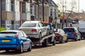 Tow truck delivers damaged vehicle staying on red traffic light in eglish city Royalty Free Stock Photo