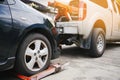 Tow truck picking up and towing old broken down car on a roadside Royalty Free Stock Photo