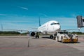 Tow truck pushes the passenger aircraft away from the boarding bridge Royalty Free Stock Photo