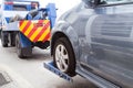 Tow truck towing a broken down car on the street