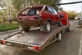 Tow truck towing a broken down car on the street