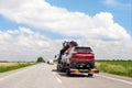 Tow truck trailer on highway carrying three damaged cars sold on insurance car auctions for repair and recovery. Vehicles