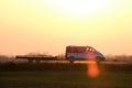 Tow truck vehicle with car carrier trailer driving on highway in evening