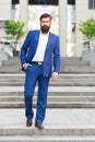 Toward business achievements. Conquer business world. Office worker confidently step on stairs. Bearded man going to