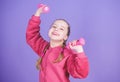 Toward healthier body. Rehabilitation concept. Girl exercising with dumbbell. Child hold little dumbbell violet Royalty Free Stock Photo