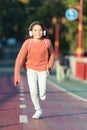 Towards happy day. Girl cute with headphones. Little child enjoy activity. Kid walking running in park listening music Royalty Free Stock Photo