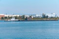 Towboat pushes dry bulk cargo barge on the river against the backdrop of an industrial landscape on the shore Royalty Free Stock Photo