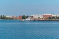 Towboat pushes dry bulk cargo barge on the river past the industrial landscape Royalty Free Stock Photo