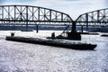 Towboat pushes dry bulk cargo barge under bridge on Mississippi River Royalty Free Stock Photo