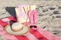 Towel with bag and beach accessories on sand Royalty Free Stock Photo