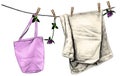 Towel and bag hanging on linen rope on wooden clothespins, rope decorated with flowers and clover leaves