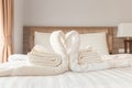Towel folded in swan / heart shape on bed sheet in bed room Royalty Free Stock Photo