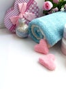 Towel, gift box, cosmetic bottle, salt scrub shape of heart on white background. Royalty Free Stock Photo