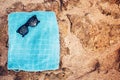Towel and sunglasses on a sandy background, fashion elements on beach day. Sandy rocks, waves and beach Royalty Free Stock Photo
