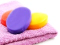 Towels with colorful pieces of soap isolated on white background Royalty Free Stock Photo