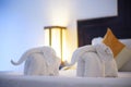 Towels in form of elephants on luxury bed in tropical beach hotel Royalty Free Stock Photo