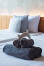 Towels roll on bed with ceramic cat. Royalty Free Stock Photo