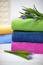 Towels in stack against the blured backdrop. Stack of green, blue, yelloy and pink towels with flowers